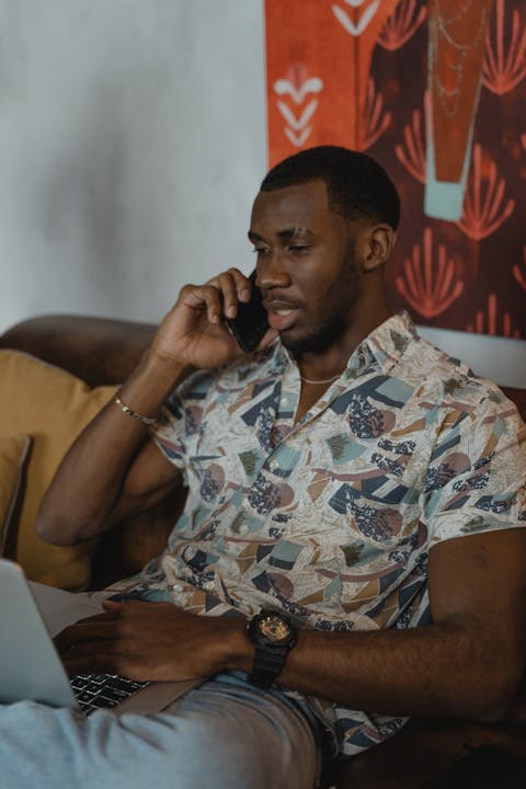 man-in-white-and-black-button-up-shirt-sitting-on-brown-chair